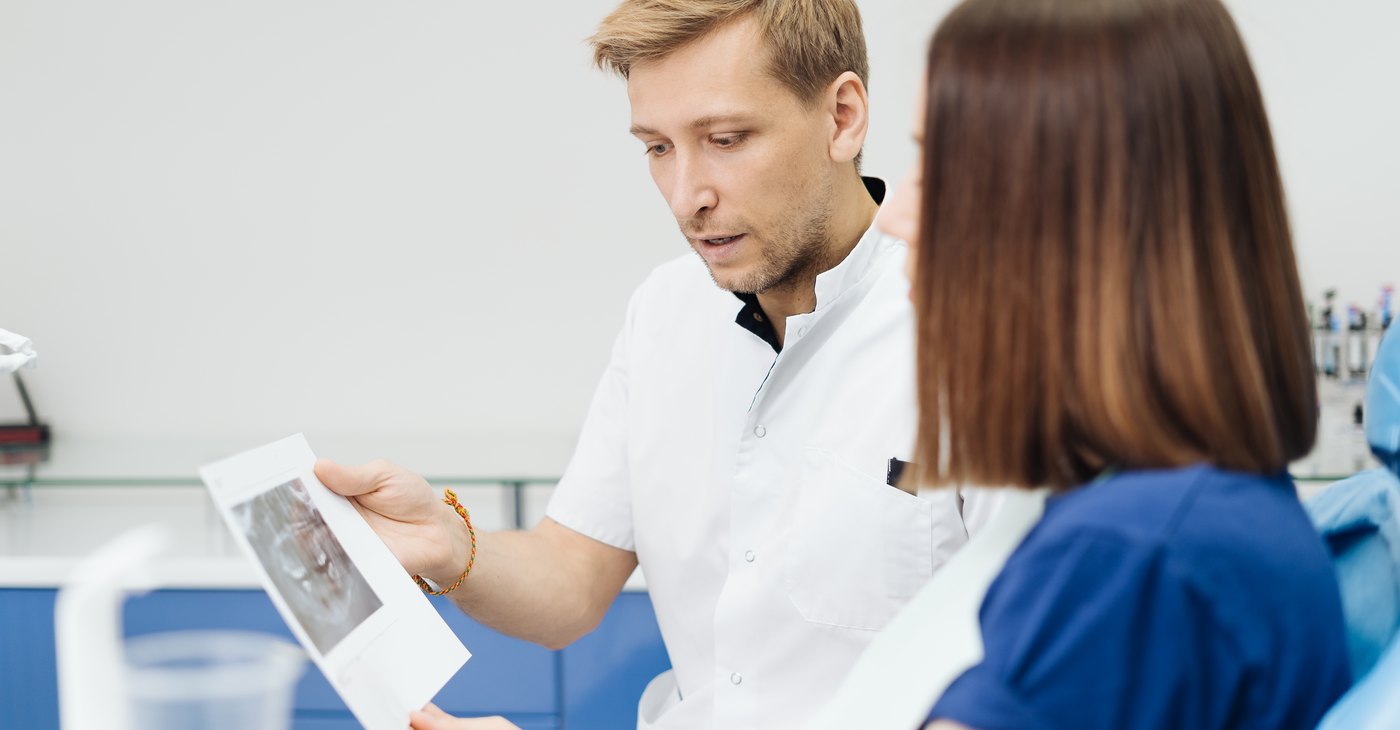 El dentista muestra una radiografía a la paciente para explicarle las opciones de tratamiento