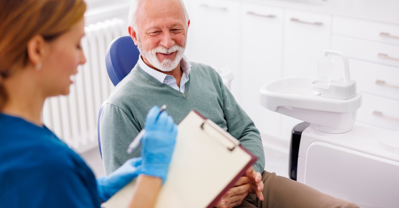 El dentista revisa el historial médico del paciente antes de plantear el implante